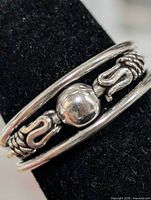 Front view showing dual bands, central bead, scroll motifs