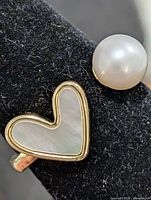 Close-up of mother-of-pearl heart and round pearl details