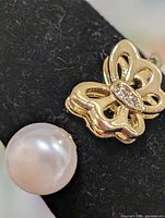 Close-up of pearl and butterfly setting