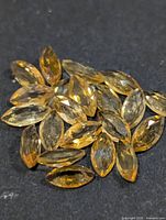 Group of marquise-cut yellow citrine stones on dark surface
