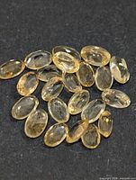 Group of oval faceted yellow citrine gemstones on dark background