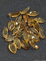 Group of marquise-cut golden citrine gemstones on dark background
