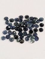 Loose round blue sapphires spread on white background