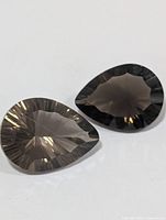 Two pear-shaped smokey quartz gems face up