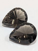 Two pear-shaped smoky quartz stones showing concave facets
