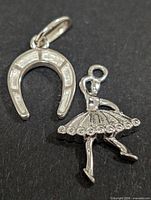 Front view of horseshoe and ballerina pendants