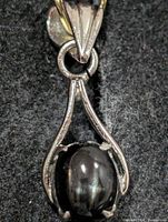 Front view of silver pendant displaying onyx stone and frame