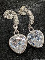 Front view of both earrings showing heart CZ drops and arc of round CZs