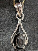 Front view of sterling silver teardrop pendant with black onyx cabochon