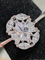 front view of silver ring showcasing cluster of marquise, baguette, round CZ stones
