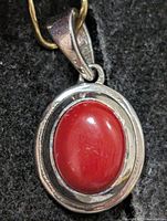 Front view showing oval red carnelian in silver bezel with bail