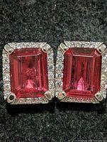 Front view of both earrings showing ruby centers and clear stone halos