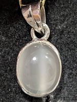 Front view of oval moonstone pendant in silver bezel