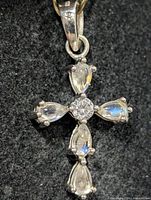 Front view of silver cross pendant showing opal cabochons and central CZ