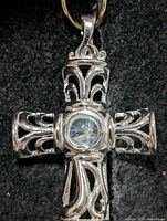 Front view of silver filigree cross pendant showing moonstone center
