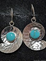 Front view of both hammered silver spiral earrings with turquoise stones