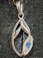 Front view of silver pendant showing marquise moonstone and leaf design