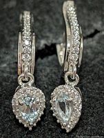 Front view showing CZ-set curve and dangling halo-set blue topaz
