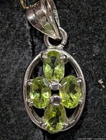 Front view of silver pendant with four peridots