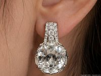 Earring worn on ear, shows scale, cut and setting