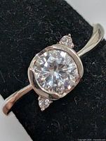 Top view of silver ring showing round CZ centre stone and accent stones