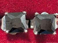 Close-up of one earring front showing square black onyx stone in silver setting