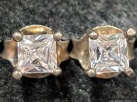 Front view showing square princess-cut stones in four-prong silver settings