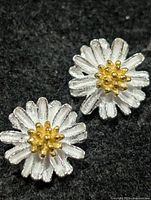 Front view showing silver petals and gold-tone centers