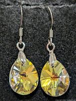 Front view of both earrings hanging, showing silver hooks and yellow teardrop crystals