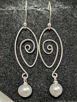 Front view of both silver spiral earrings with pearl drops