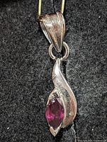 Front view of silver pendant with marquise garnet