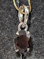 Front view of silver pendant with oval garnet