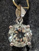 Front view of silver pendant with round green amethyst in four-prong setting