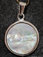 Front view showing full mother of pearl disc in silver bezel