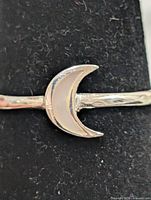 Front view of crescent moon mother-of-pearl ring on display stand