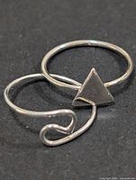 Both silver-tone rings side-by-side showing designs
