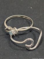 Two sterling silver rings side by side showing designs