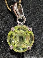 Front view of silver pendant highlighting peridot gemstone and prong setting