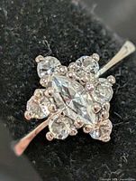 Front view of silver ring displaying marquise center stone and surrounding round stones