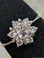 Top view of silver-tone cluster ring showing floral arrangement of clear stones