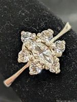 Front view showing marquise center and round stones cluster
