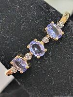 Top view of ring showing three oval tanzanites and accent stones