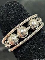 Front view of silver-tone toe ring showing three beads between parallel bands