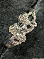 Front view showing twin puppy figures on ring