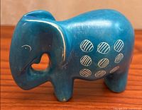 Left side view of blue soapstone elephant figurine showing carved circle pattern