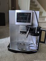 Front view showing overall machine with milk carafe attached