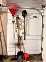 Group of hanging garden tools, snow shovel and gas can