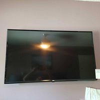 Front view of LG 43-inch flat screen TV mounted on wall