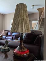 Full view of lamp on side table showing base, neck and shade