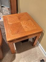Full view of oak end table showing veneered top, brass inlay and legs